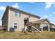 A spacious backyard with a wooden playset and a covered patio on a sunny day at 833 Ember Dr, Durham, NC 27703