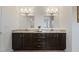 This is a well-lit bathroom with a double sink, granite countertop, and dark cabinetry at 833 Ember Dr, Durham, NC 27703