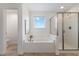 This is a well-lit bathroom showcasing a tub with a glass enclosed shower at 833 Ember Dr, Durham, NC 27703