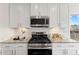 Modern kitchen with stainless steel appliances, granite countertops, and white cabinetry at 833 Ember Dr, Durham, NC 27703