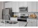 Modern kitchen features stainless steel appliances, granite countertops, and a breakfast bar at 878 John St, Clayton, NC 27520