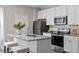 Well-equipped kitchen boasts an island with seating, granite countertops, and stainless appliances at 878 John St, Clayton, NC 27520