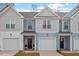 Charming townhome exteriors featuring light blue and grey siding, attached garages, and inviting front doors at 882 John St, Clayton, NC 27520