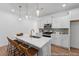 Bright kitchen with white cabinets, stainless appliances, and quartz countertop island with barstool seating at 92 Horseshoe Pl # 9, Angier, NC 27501