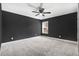 This bedroom features dark grey walls, a ceiling fan, carpet, and a window letting in natural light at 10 W Ravano Dr, Clayton, NC 27527