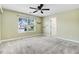 This bedroom features a ceiling fan, shelving, carpet, and a window letting in natural light at 10 W Ravano Dr, Clayton, NC 27527