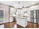 Bright kitchen featuring white cabinets, granite countertops, a stainless steel refrigerator, and a center island at 10 W Ravano Dr, Clayton, NC 27527