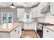 Well-lit kitchen with white cabinetry, granite counters, an island, and stainless steel appliances at 10 W Ravano Dr, Clayton, NC 27527