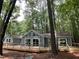 Expansive wooden deck overlooking wooded lot with large windows and glass doors at 102 Pebble Ct, Chapel Hill, NC 27516