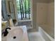 Bathroom featuring a quartz vanity, sleek black fixtures, a bathtub, and green backyard views at 102 Pebble Ct, Chapel Hill, NC 27516