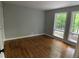 Empty bedroom featuring hardwood floors, light paint, and windows overlooking a wooded area at 102 Pebble Ct, Chapel Hill, NC 27516