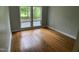 Bedroom featuring hardwood floors, light paint, and windows overlooking a wooded area at 102 Pebble Ct, Chapel Hill, NC 27516
