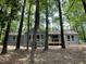 Exterior view of a house surrounded by trees with a wooden deck and light blue paint at 102 Pebble Ct, Chapel Hill, NC 27516