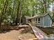 Charming one-story home with blue siding and a welcoming walkway surrounded by lush greenery at 102 Pebble Ct, Chapel Hill, NC 27516