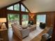 Open living room featuring vaulted ceilings, wood paneled walls, and a sliding glass door to the deck at 102 Pebble Ct, Chapel Hill, NC 27516
