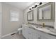 Bathroom featuring a dual sink vanity with marble counters and modern light fixtures at 104 Archdale Dr, Durham, NC 27707