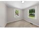 Bright bedroom with neutral carpet, and natural light from two windows at 104 Archdale Dr, Durham, NC 27707