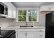 Bright kitchen features white cabinets, granite countertops, and a stainless steel sink at 104 Archdale Dr, Durham, NC 27707