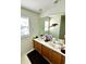 Bright bathroom featuring a double sink vanity with framed mirror and natural light from window at 104 Fox Trail Ln, Morrisville, NC 27560
