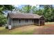 The backyard shows the back side of a house with a screened porch and propane tank at 106 Nations Cove, Louisburg, NC 27549