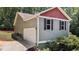 A home with grey siding, white garage door and a yard with green bushes at 106 Nations Cove, Louisburg, NC 27549