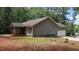 View of home with side-entry garage, screened porch, horizontal siding, and spacious yard with mature trees at 106 Nations Cove, Louisburg, NC 27549