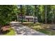 Exterior view of the home, nestled among mature trees and a long drive at 106 Nations Cove, Louisburg, NC 27549