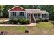 Charming home featuring a quaint front porch, landscaped yard, and tree-lined backdrop at 106 Nations Cove, Louisburg, NC 27549