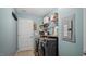 This laundry room has a washer and dryer, shelving, and a door to another room at 106 Nations Cove, Louisburg, NC 27549