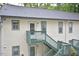 Two-story apartment building featuring painted siding, green trim, and stairs to the second level at 107 Ashley Forest Rd # B, Chapel Hill, NC 27514