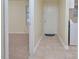 Hallway with tile floors leading to a carpeted living area; featuring a white front door at 107 Ashley Forest Rd # B, Chapel Hill, NC 27514
