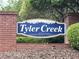 Tyler Creek community sign atop a brick base with foliage at 107 Ashley Forest Rd # B, Chapel Hill, NC 27514