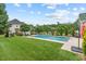 Backyard featuring a large in-ground pool, green grass, and a tree lined fence at 107 Regiment Way, Durham, NC 27705