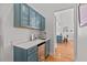 Stylish bar area with blue cabinets, quartz countertops, and a wine fridge at 107 Regiment Way, Durham, NC 27705