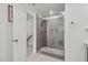 Modern bathroom featuring a glass shower with gray tiling and a pebble floor, and wood look plank tile flooring at 107 Regiment Way, Durham, NC 27705