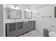 Bright bathroom features double vanities, framed mirrors, and modern fixtures with white walls and gray tile flooring at 107 Regiment Way, Durham, NC 27705