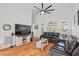 Spacious living room with hardwood floors, a large TV, and comfortable leather seating at 107 Regiment Way, Durham, NC 27705