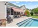 Backyard patio featuring an outdoor dining set and sunshade, adjacent to the in-ground pool for easy access at 107 Regiment Way, Durham, NC 27705