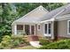 Inviting front porch with brick steps, a neutral color palette, white railings, and glimpses of lush greenery at 108 Ripplewater Ln, Cary, NC 27518
