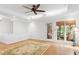 Bright living room featuring hardwood floors, a ceiling fan, and large windows with natural light at 108 Ripplewater Ln, Cary, NC 27518