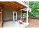 A comfortable patio with a rug and chair is situated beneath a raised porch with white pillars at 108 Ripplewater Ln, Cary, NC 27518