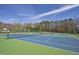 Well-maintained outdoor tennis courts with blue and green surfaces surrounded by trees and lighting fixtures at 108 Ripplewater Ln, Cary, NC 27518