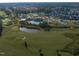An aerial view of the golf course and community pool, featuring a pond and lush green landscape at 109 Big Timber Path, Holly Springs, NC 27540