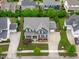 An aerial view of a well-manicured gray home with a spacious driveway, lush green lawns and mature trees at 109 Big Timber Path, Holly Springs, NC 27540