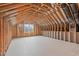 Spacious unfinished attic space with exposed wood framework and a bright window at 109 Big Timber Path, Holly Springs, NC 27540
