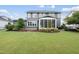 Spacious backyard featuring lush lawn, mature trees, and a charming screened-in porch at 109 Big Timber Path, Holly Springs, NC 27540