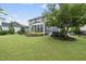 Expansive backyard with green lawn, mature trees, and inviting screened-in patio at 109 Big Timber Path, Holly Springs, NC 27540