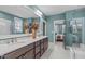 Dual sink bathroom vanity with stone countertop and modern fixtures, next to walk-in shower at 109 Big Timber Path, Holly Springs, NC 27540