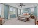 Comfortable bedroom with many windows, a ceiling fan, neutral carpet, and furnishings at 109 Big Timber Path, Holly Springs, NC 27540