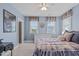 Comfortable bedroom with a light blue color scheme and two bright, airy windows at 109 Big Timber Path, Holly Springs, NC 27540